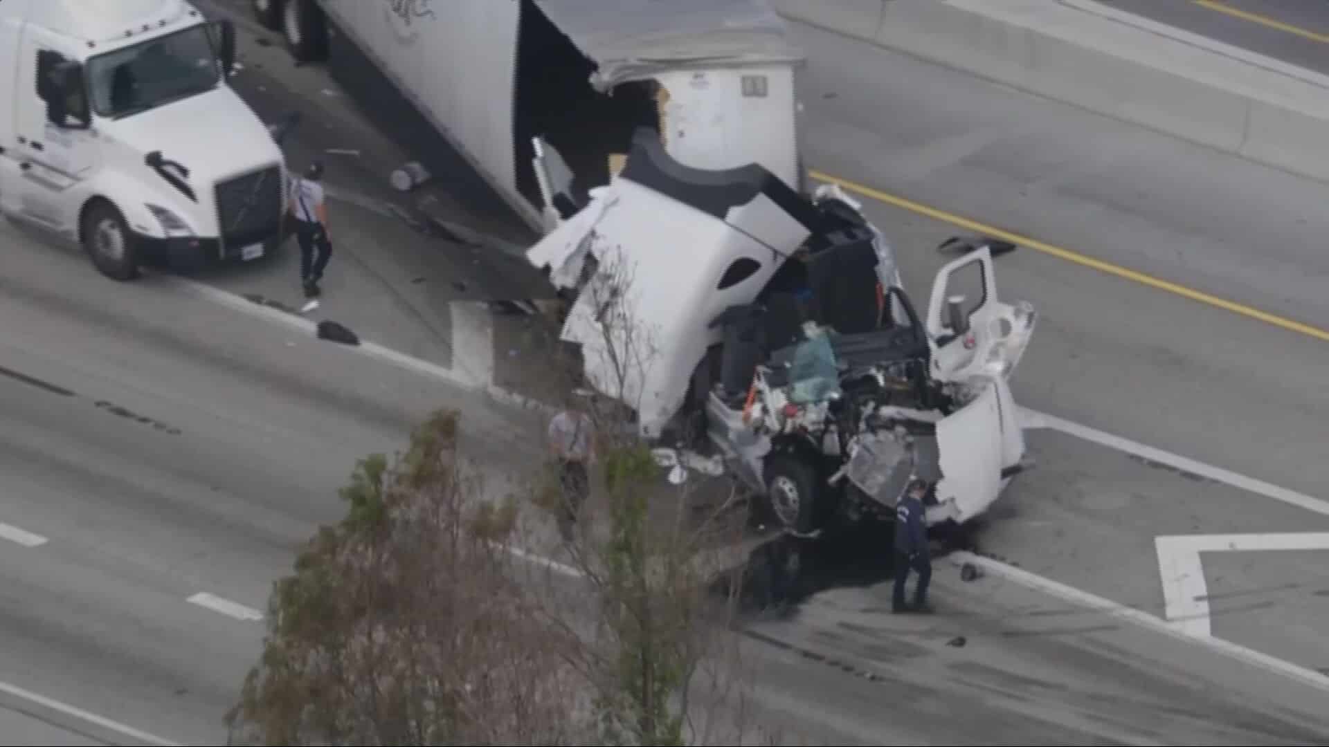 Accidente de camión en la carretera con remolque dañado y personal de emergencia