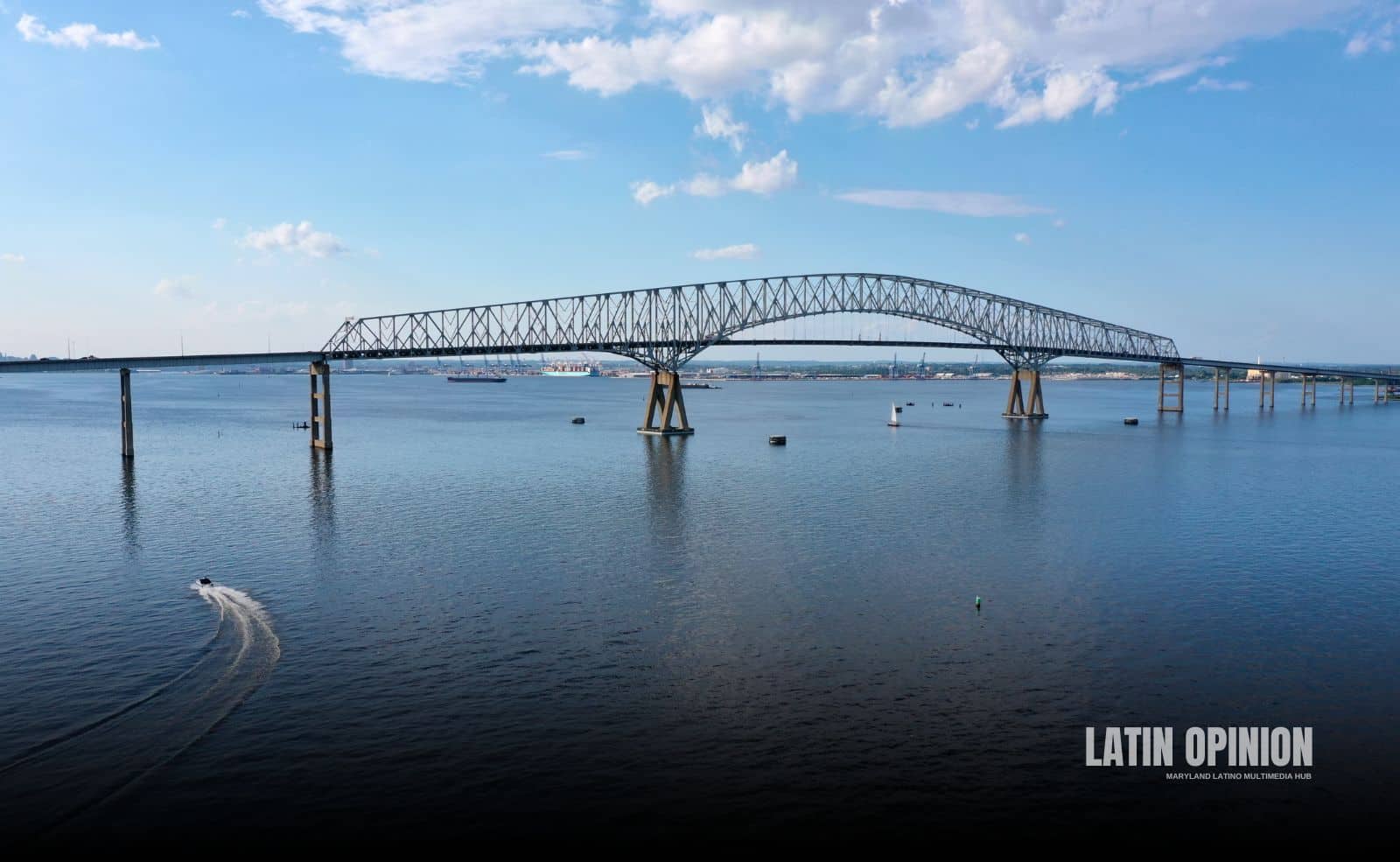 Puente moderno arqueado en Baltimore sobre cuerpo de agua con barcos navegando