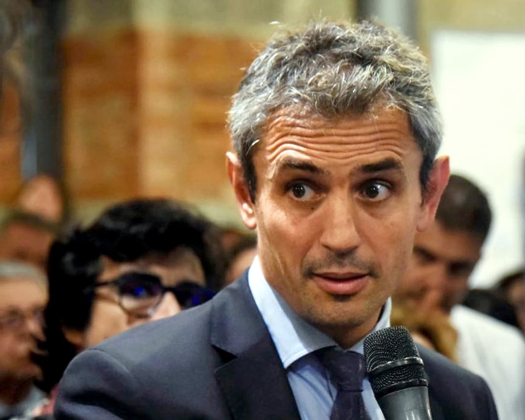 Mart&iacute;n Menem en evento p&uacute;blico sosteniendo un micr&oacute;fono