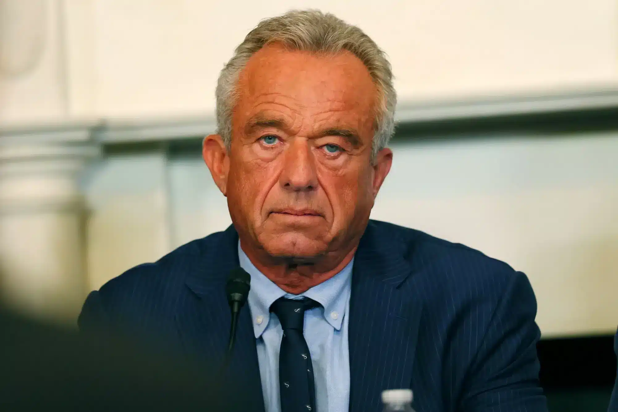 Hombre serio frente a micr&oacute;fono en evento p&uacute;blico