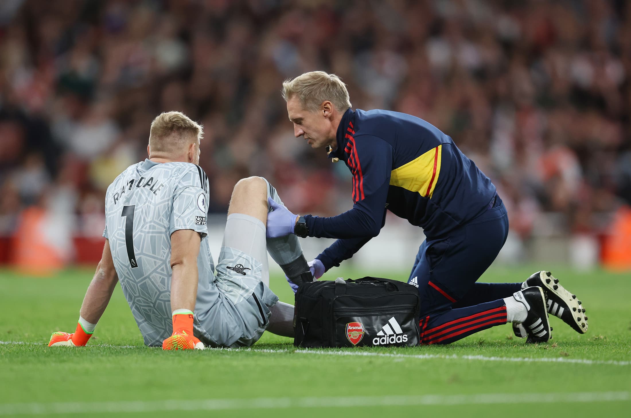 Jugador de fútbol recibiendo atención médica por lesión en la pierna
