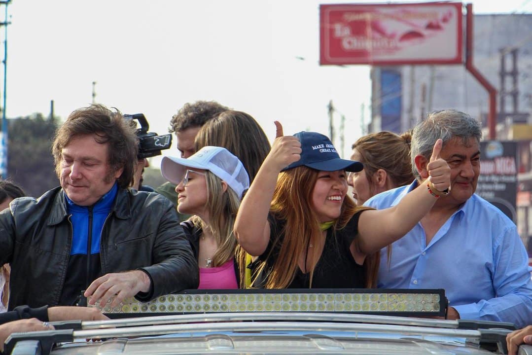 Grupo de personas en acto político mostrando entusiasmo