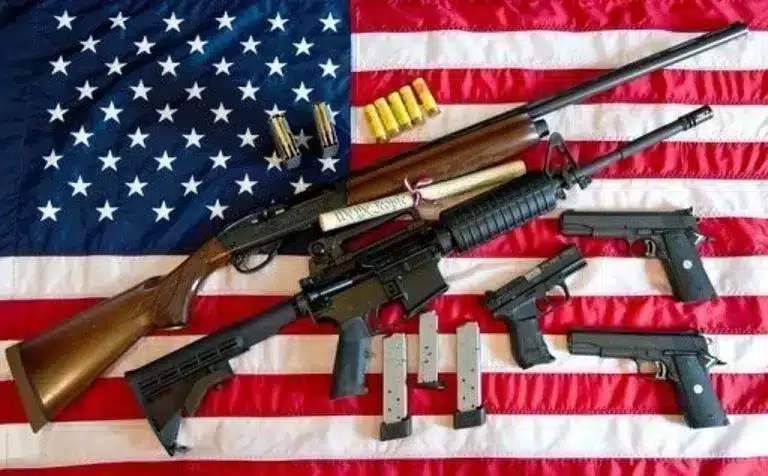 Armas de fuego sobre bandera estadounidense representando el debate cultural