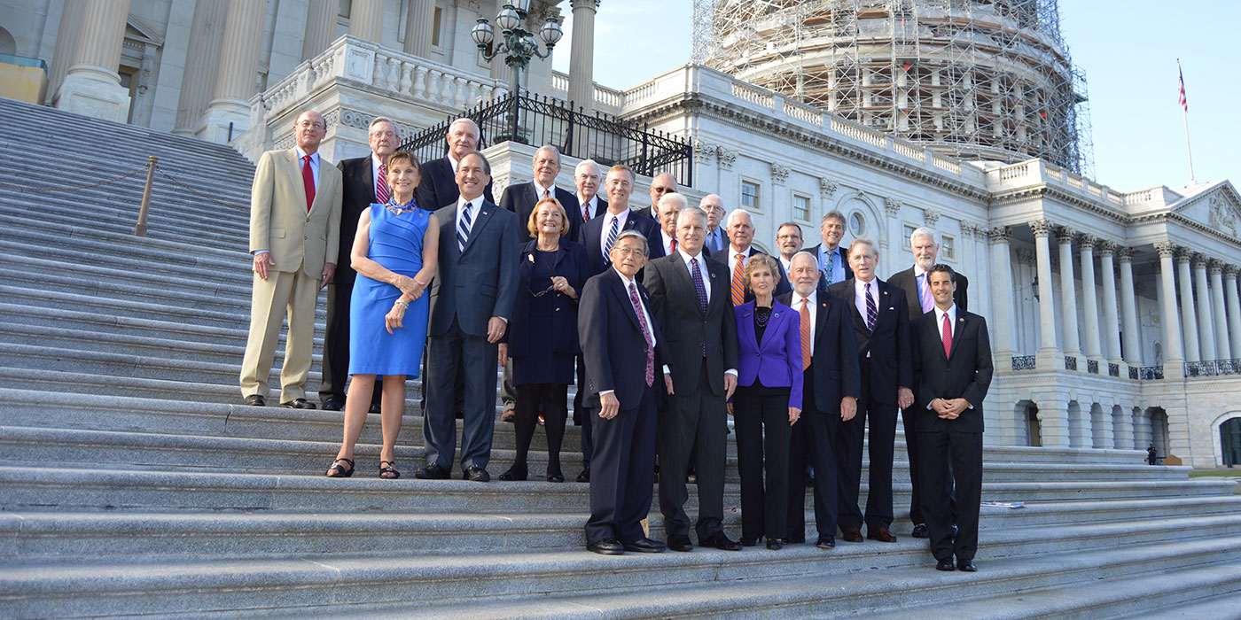 Grupo de funcionarios en el Capitolio con andamiaje de fondo