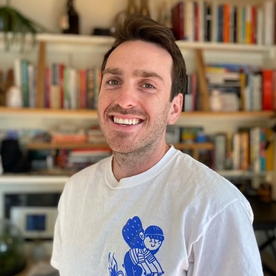 Asesor pol&iacute;tico sonriendo con estanter&iacute;as de libros de fondo