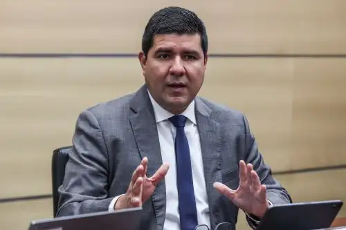 Hombre en reuni&oacute;n gesticulando con traje gris