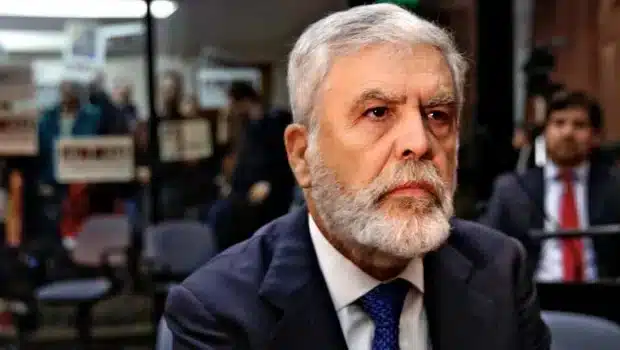 Escena de audiencia judicial con manifestantes en fondo