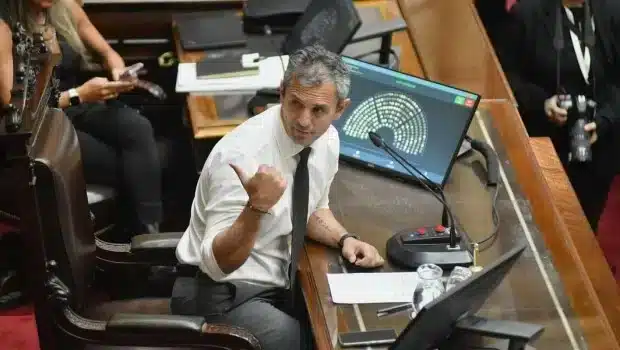 Hombre en ambiente legislativo utilizando dispositivo de votaci&oacute;n