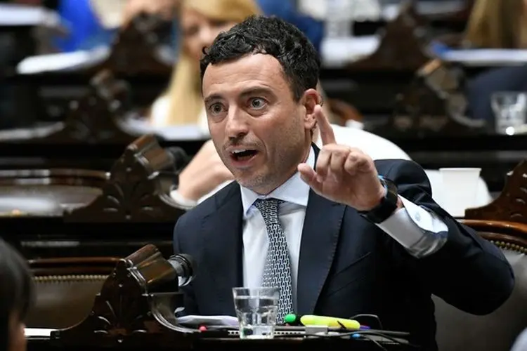 Hombre en traje participando en debate legislativo
