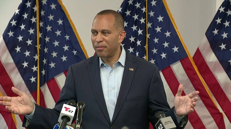 Hombre frente a banderas estadounidenses en conferencia de prensa