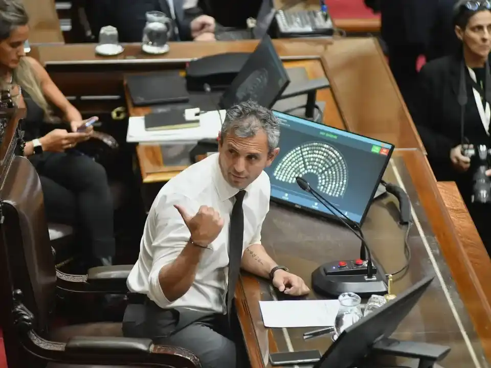 Hombre gesticulando en entorno legislativo