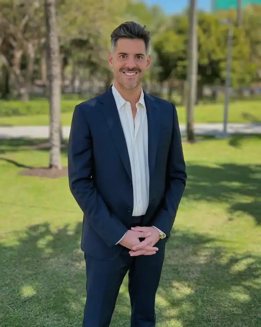 Escena política en Miami Beach mostrando a un candidato en un entorno ajardinado