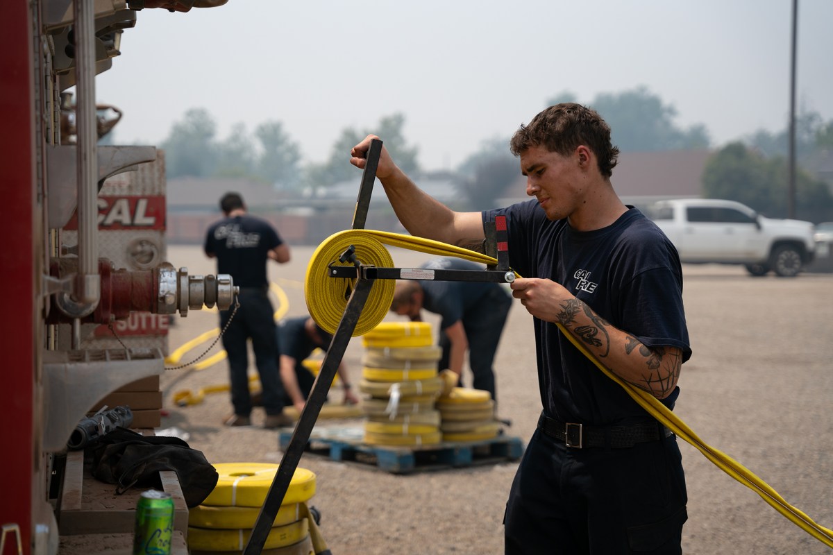 Equipos combatiendo incendios en California con mangueras y cami&oacute;n de bomberos