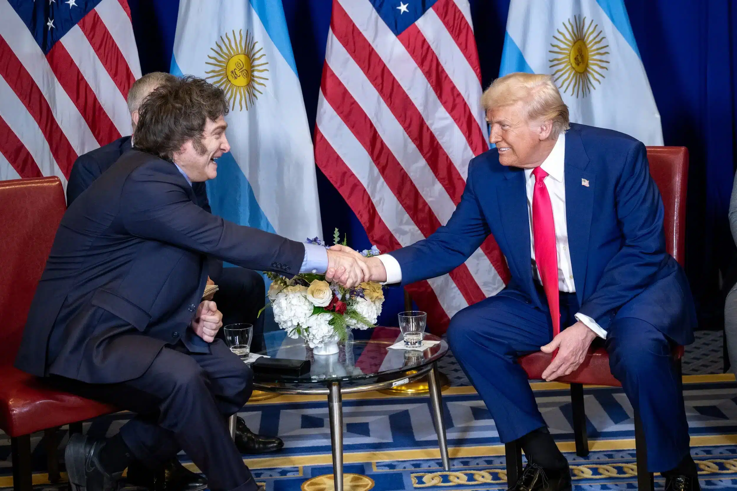 Javier Milei y Donald Trump estrechando manos en un acto formal