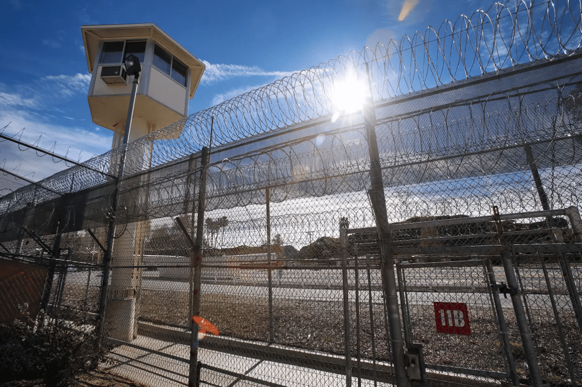 Entorno penitenciario con muro de alambre de p&uacute;as y torre de vigilancia