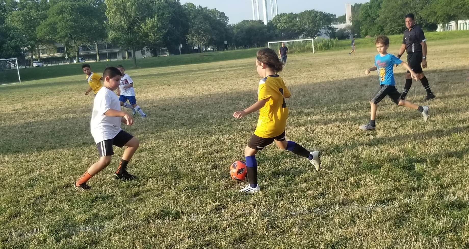 J&oacute;venes futbolistas en acci&oacute;n durante un partido, representando el esp&iacute;ritu del f&uacute;tbol juvenil