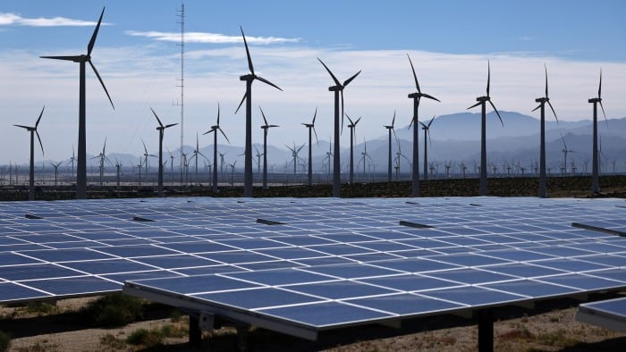 Paneles solares y turbinas e&oacute;licas bajo un cielo despejado
