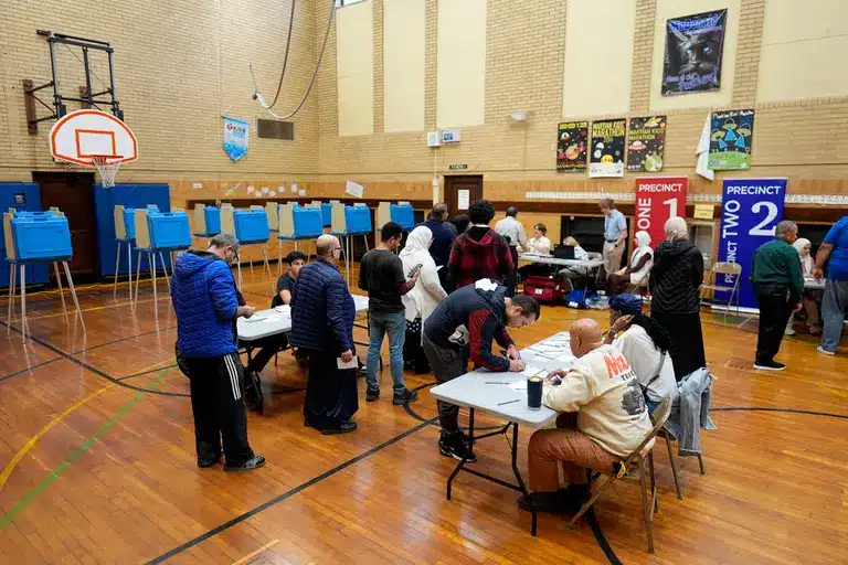 Centro de votación en un gimnasio con electores