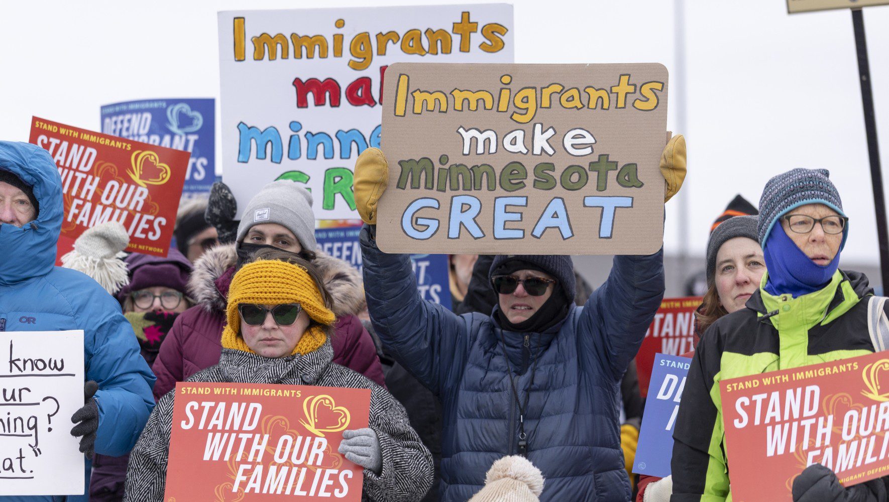 Manifestantes con carteles pro-inmigrantes en clima fr&iacute;o