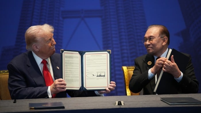 Dos hombres en un acto formal, posiblemente firmando un acuerdo comercial