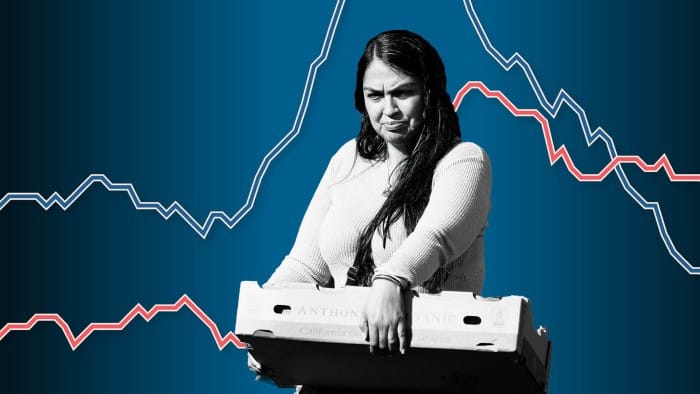 Mujer con expresi&oacute;n preocupada sosteniendo una caja, con gr&aacute;ficos de tendencias econ&oacute;micas al fondo