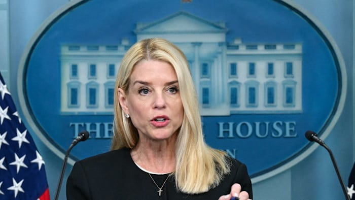 Mujer rubia hablando en podio con sello de la Casa Blanca