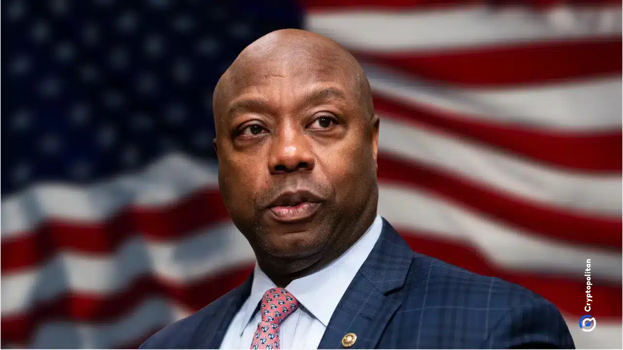 El senador Tim Scott en un entorno político formal, con expresión seria y la bandera estadounidense de fondo