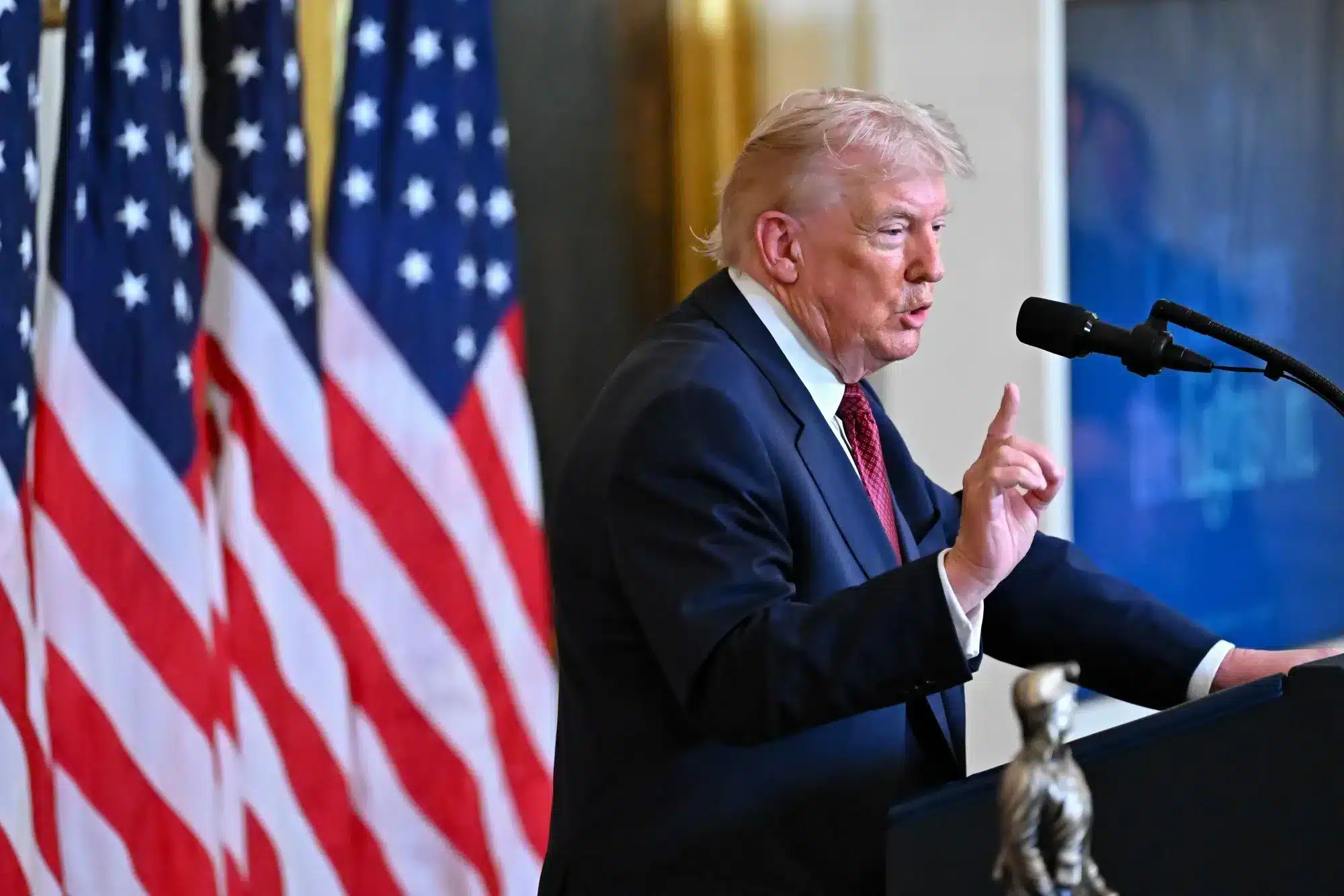Hombre hablando en un atril con banderas estadounidenses