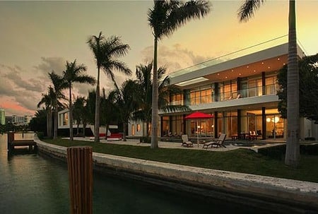 Moderno mansión de lujo junto a un canal en Miami al atardecer