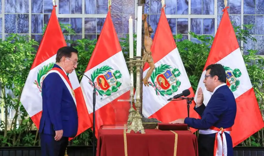 Ceremonia de juramentación de Felipe Meza Millán como ministro, con el presidente Balcázar observando, en un ambiente formal con banderas peruanas