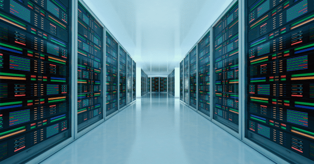 Pasillo moderno de un centro de datos con servidores avanzados y luces de colores, representando la infraestructura de IA