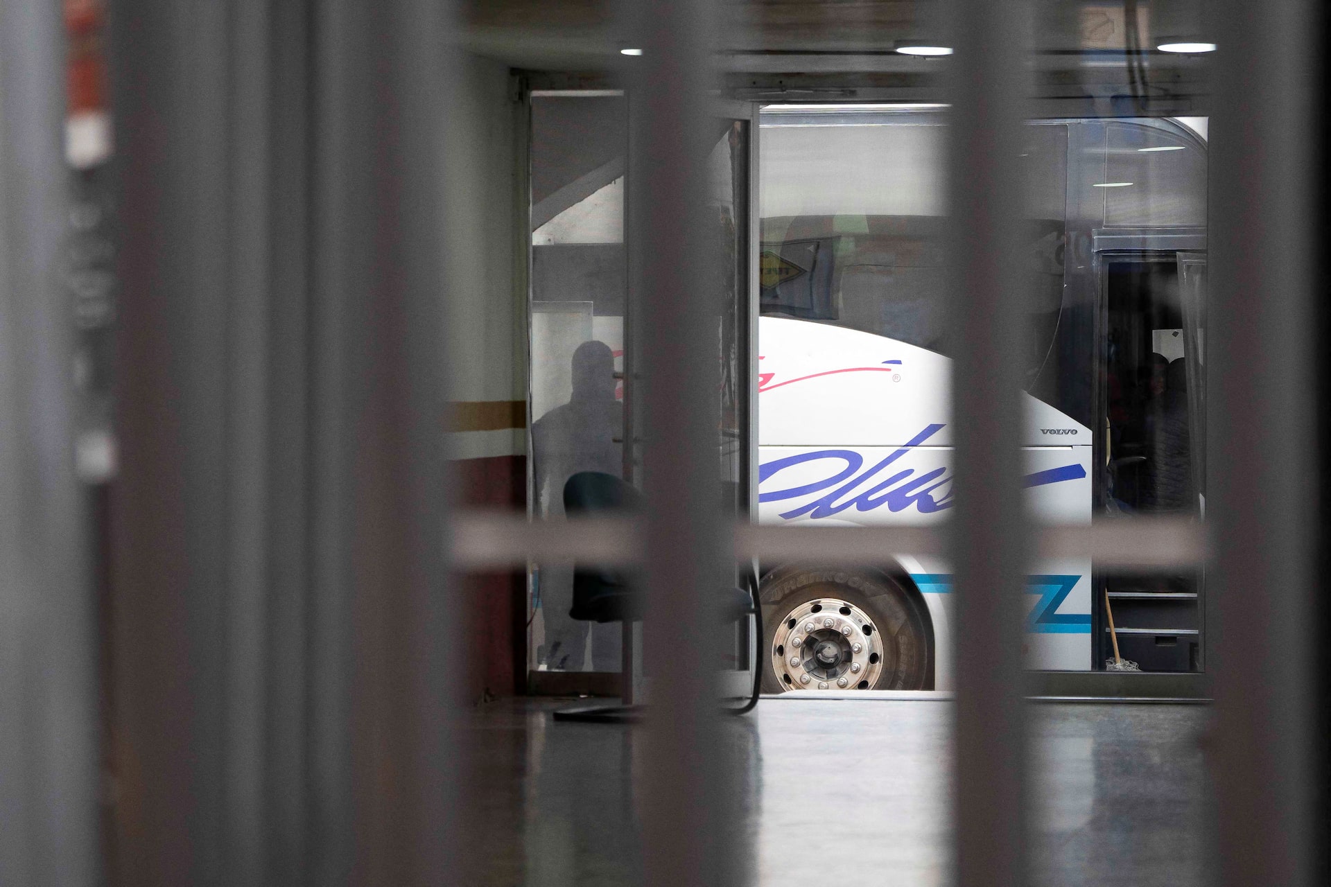 Entorno con rejas y autobús para el transporte de deportados