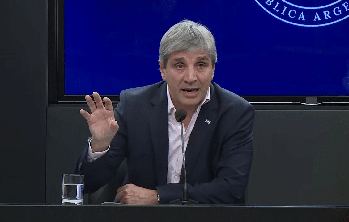 Luis Caputo hablando en una conferencia de prensa, gesticulando con la mano en un gesto de &eacute;nfasis