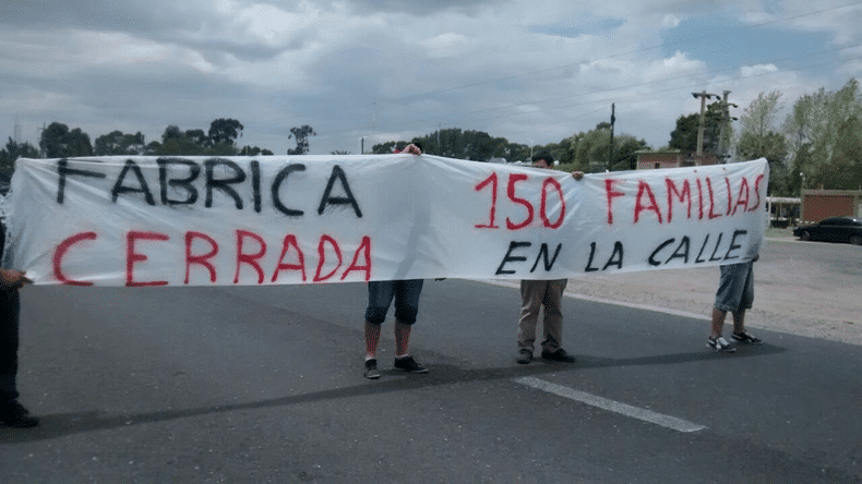 Protesta con pancarta que dice FABRICA CERRADA 150 FAMILIAS EN LA CALLE