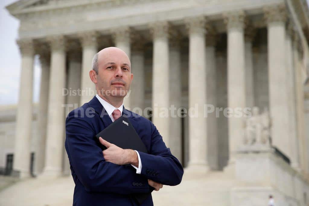 Abogado con brazos cruzados y documentos frente a la Corte Suprema