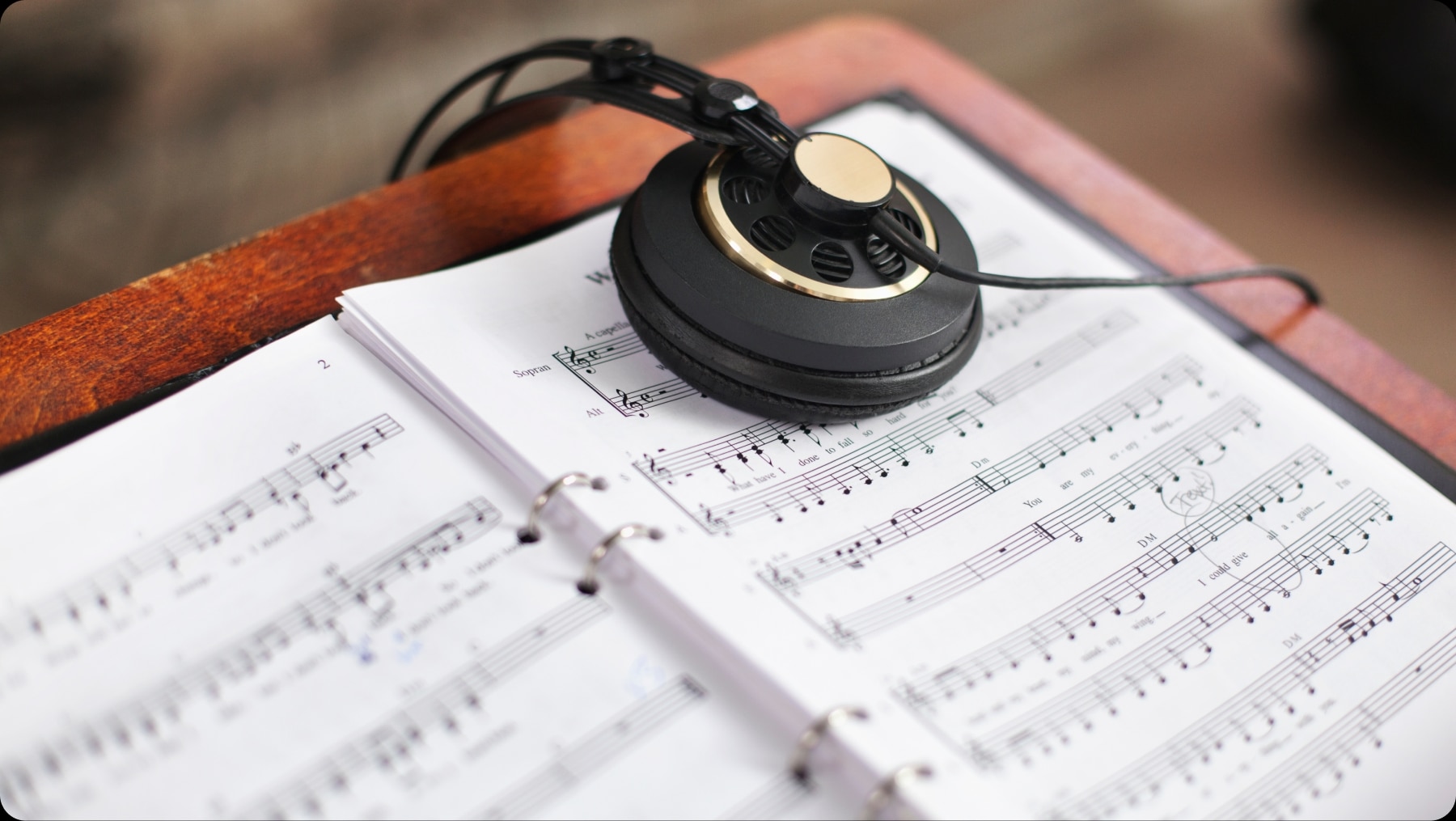 Partitura musical con auriculares, representando la creaci&oacute;n de m&uacute;sica