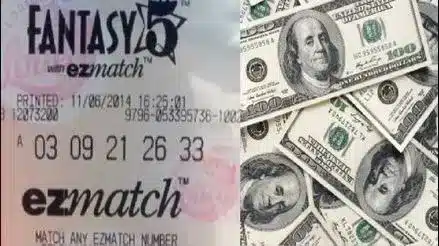 Ticket de Fantasy 5 junto a billetes de cien d&oacute;lares