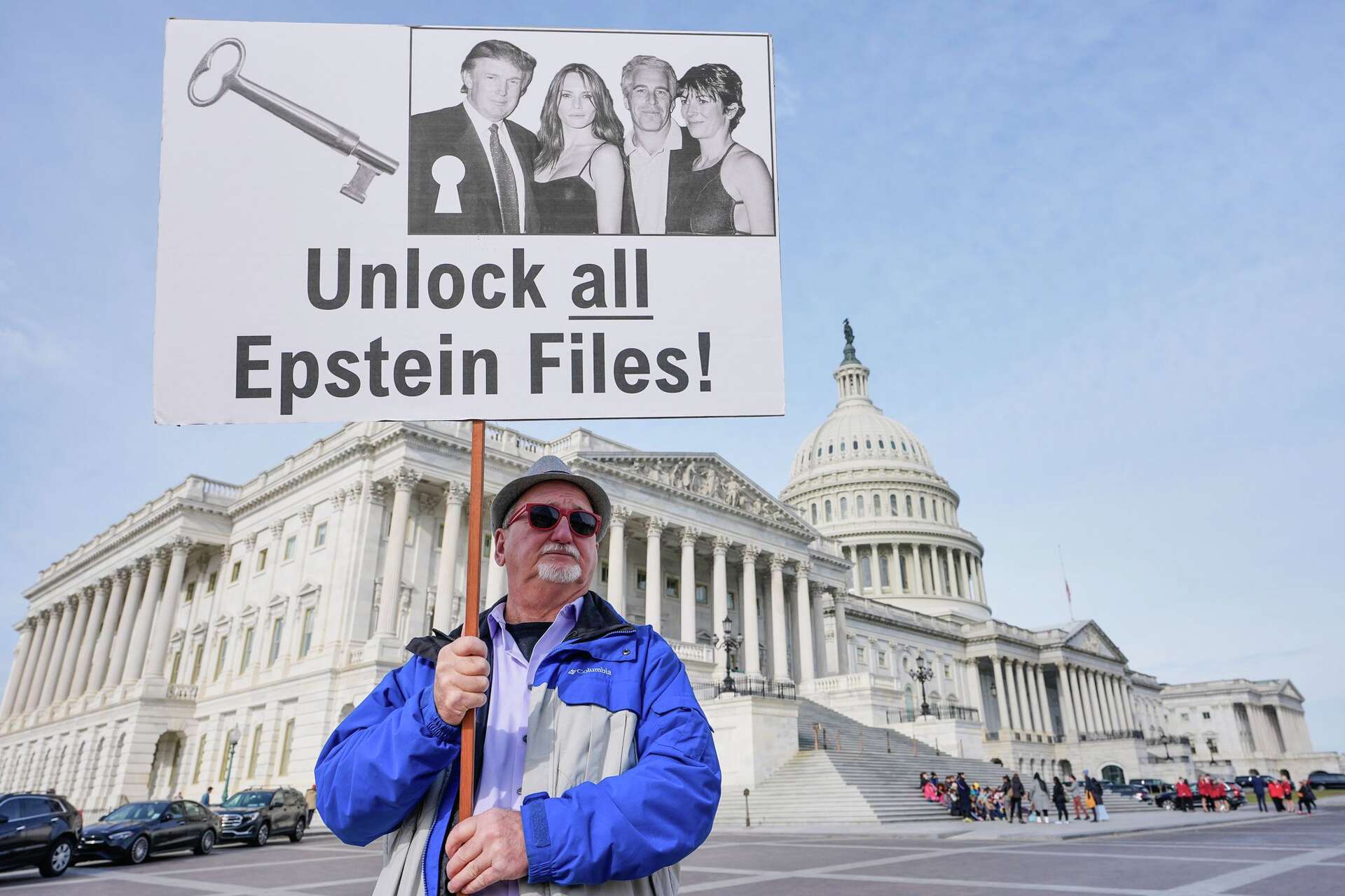 Hombre protestando con cartel 'Unlock all Epstein Files' frente al Capitolio de EE.UU.
