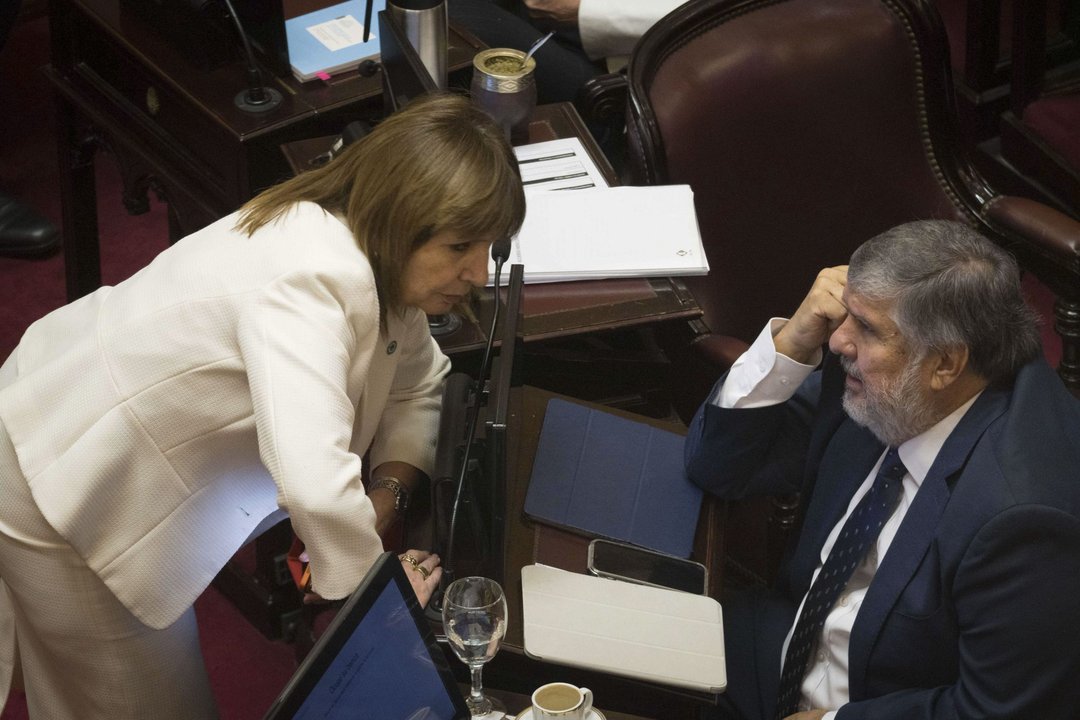 Conversaci&oacute;n en el recinto del Senado entre dos personas