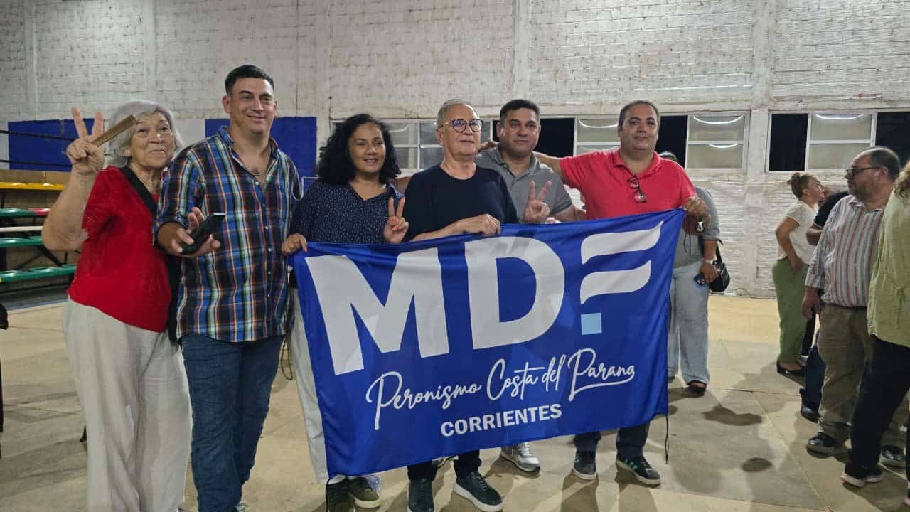 Grupo sosteniendo bandera del Movimiento Derecho al Futuro, haciendo gesto de paz