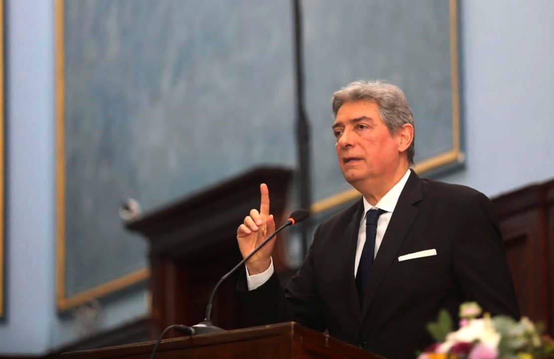 Hombre hablando en un podio en un recinto institucional