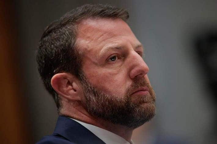 Markwayne Mullin de perfil, con expresi&oacute;n seria y concentrada, vestido con traje formal