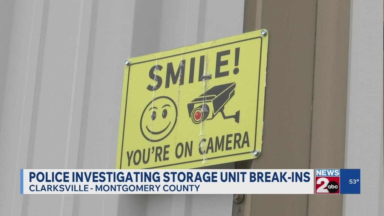 Cartel de seguridad en unidad de almacenamiento que dice 'SMILE! YOU'RE ON CAMERA'