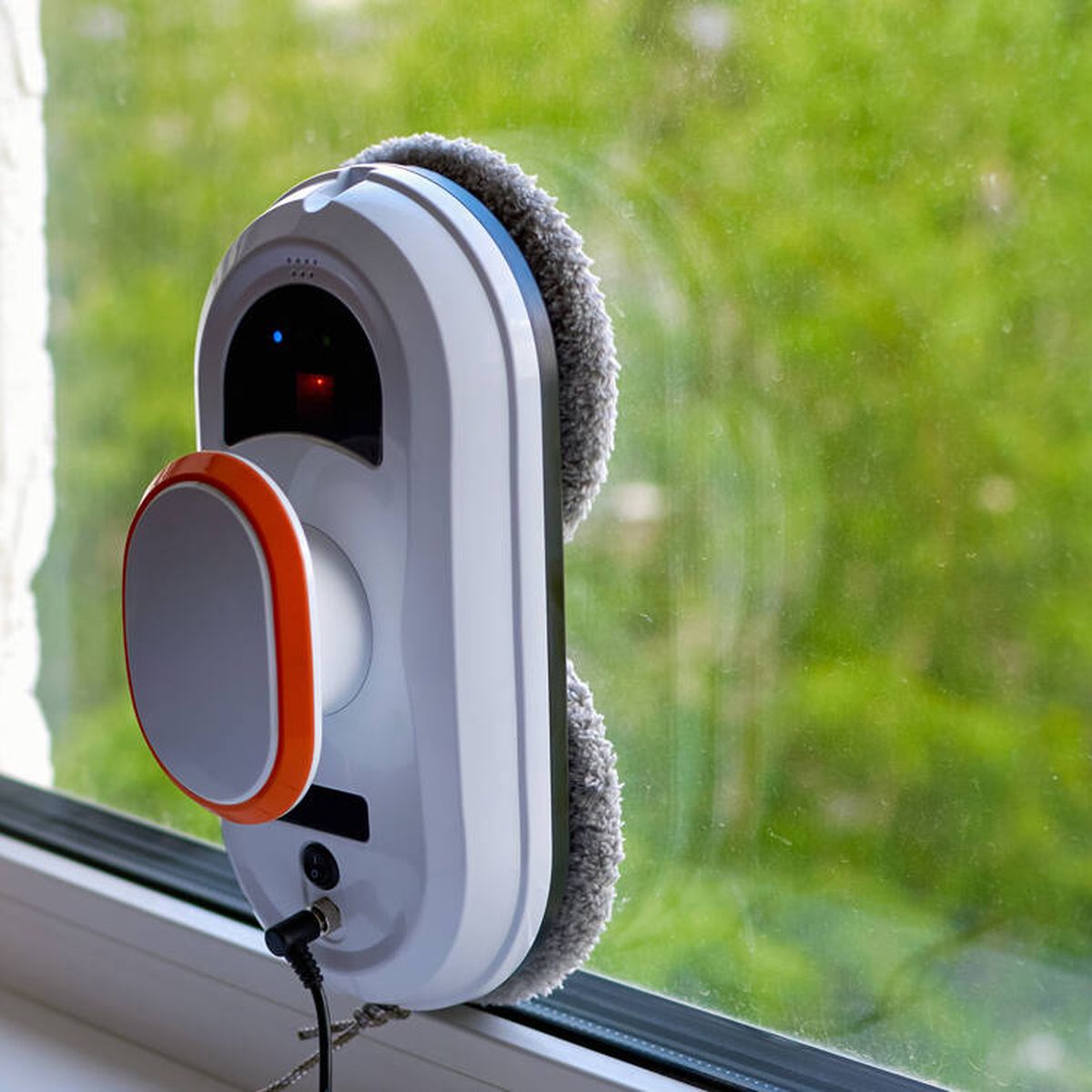Robot limpiador de ventanas operando en el exterior, con diseño moderno en blanco y naranja