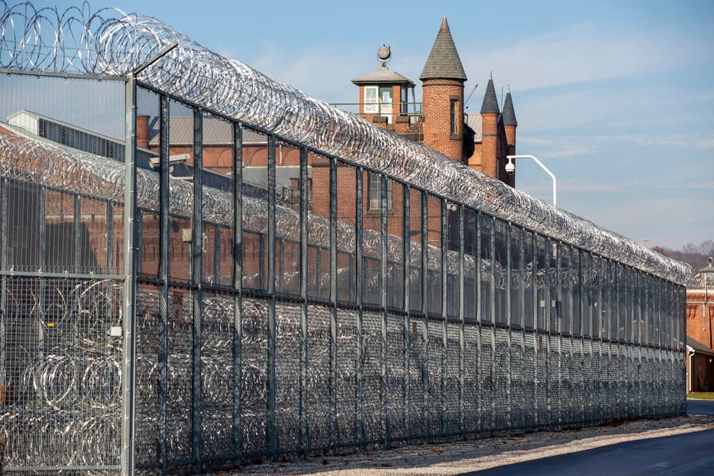 Vista exterior del Centro Correccional Metropolitano (MCC) en Manhattan, con alambre de púas y torres de vigilancia