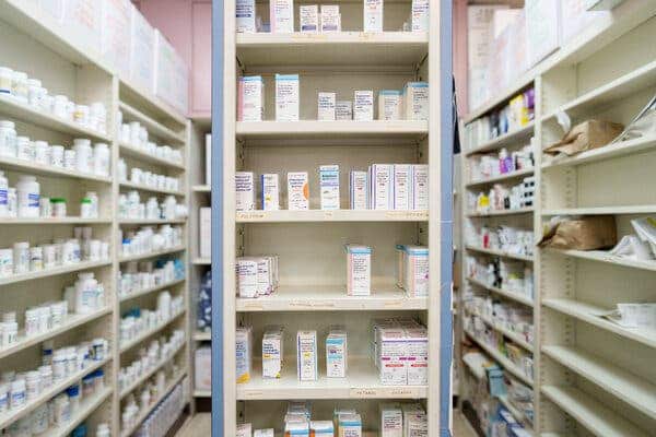 Estante de farmacia con medicamentos, mostrando la diversidad de productos farmac&eacute;uticos