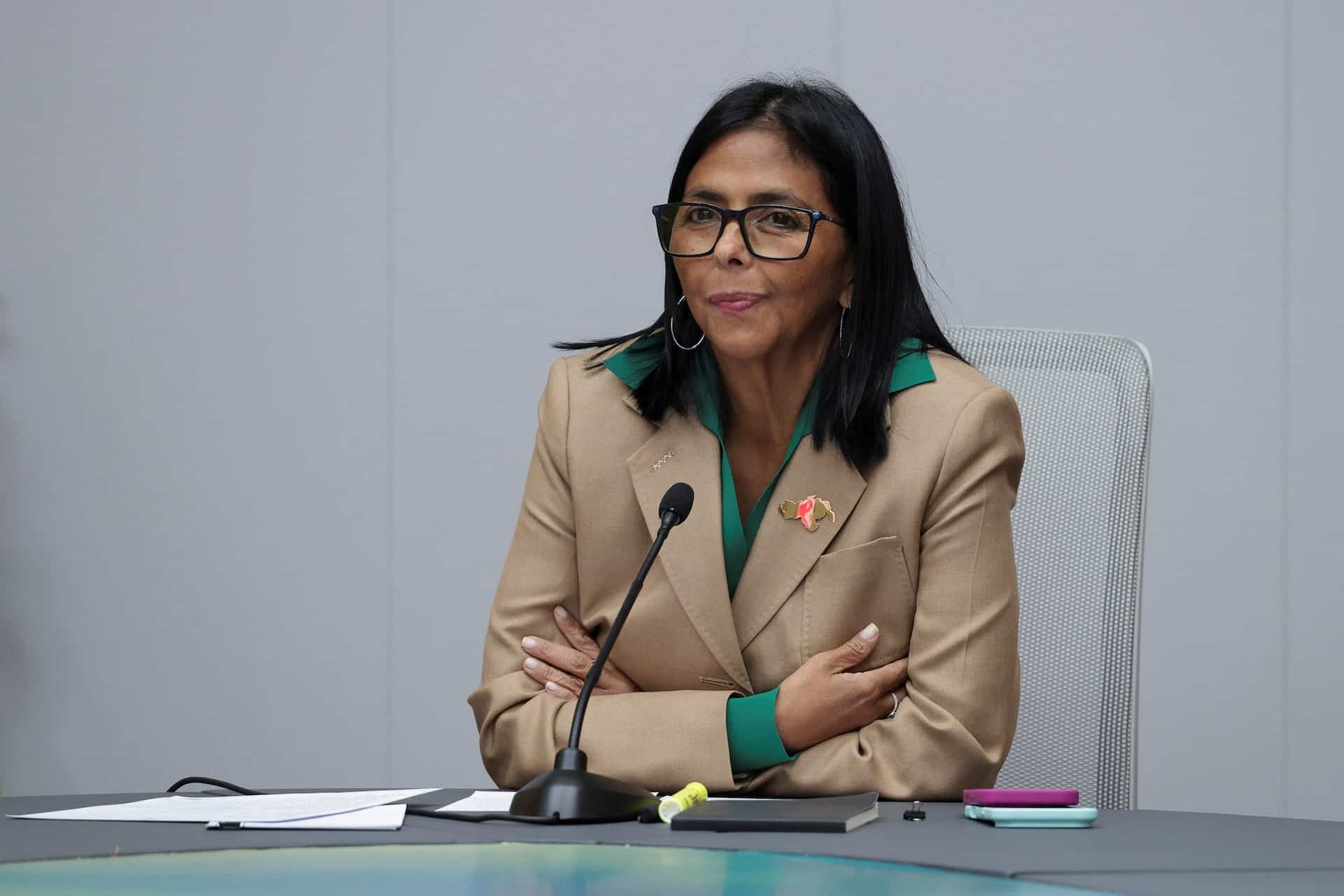 Delcy Rodr&iacute;guez sentada en una mesa formal con documentos