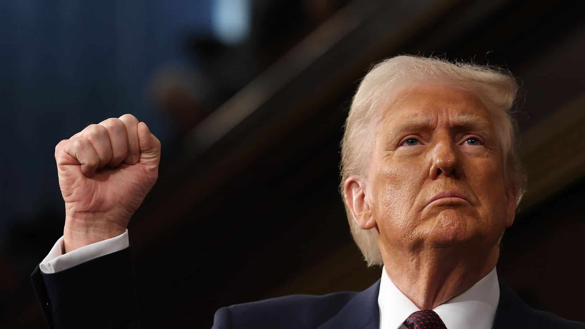 Donald Trump con expresi&oacute;n seria y pu&ntilde;o en alto durante un mitin