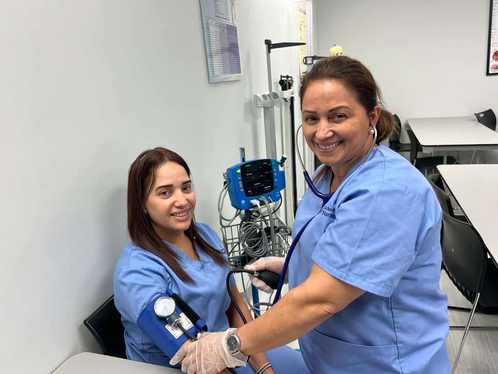 Estudiantes practicando toma de presi&oacute;n arterial en un entorno cl&iacute;nico