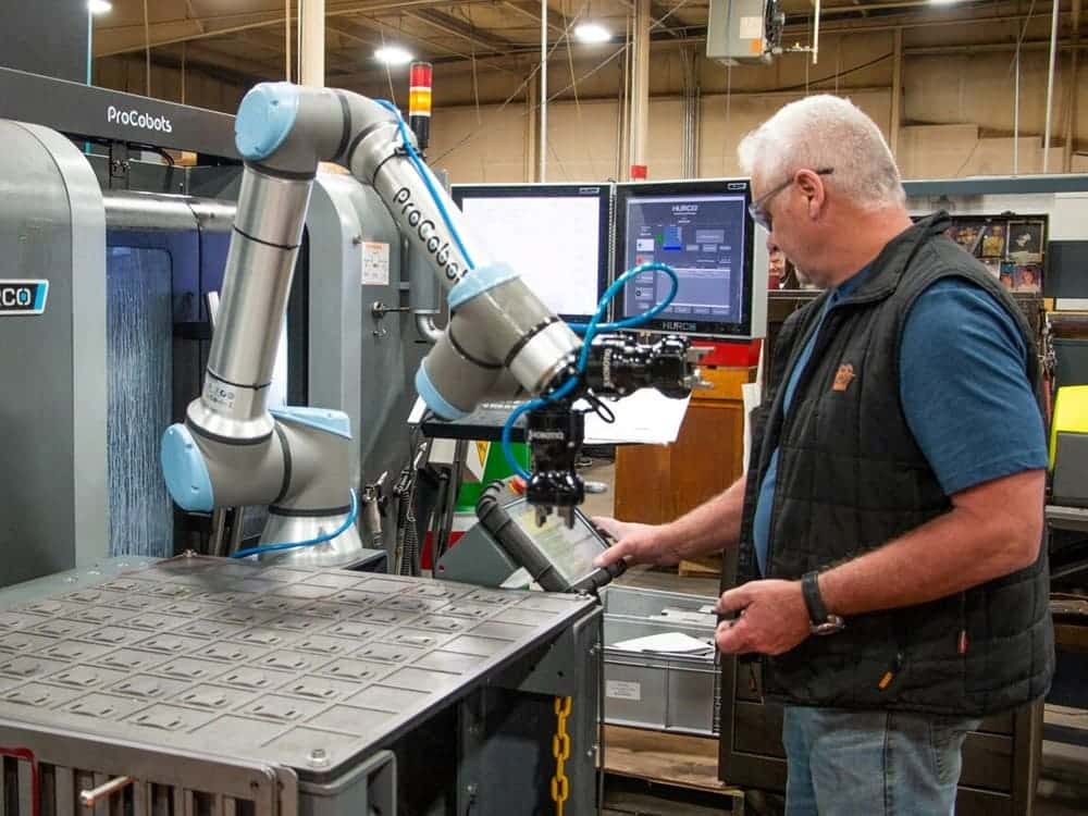Operario trabajando junto a un robot colaborativo en una fábrica
